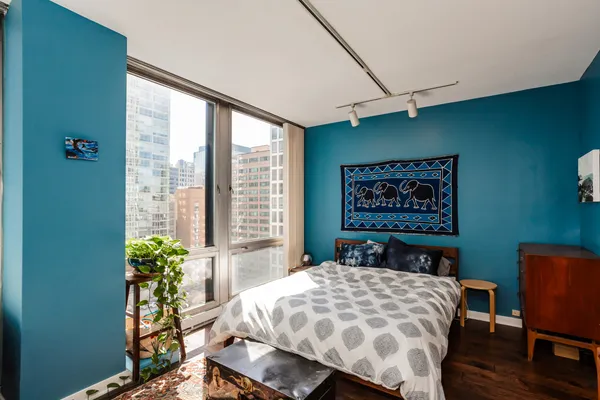 a large bed sitting in a bedroom next to a window