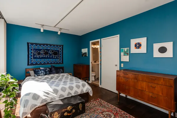 a bedroom with a bed and dresser with wall paintings