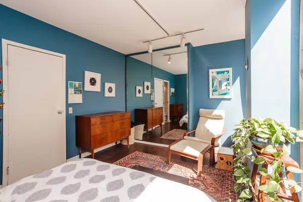 a bedroom with a bed and wooden floor