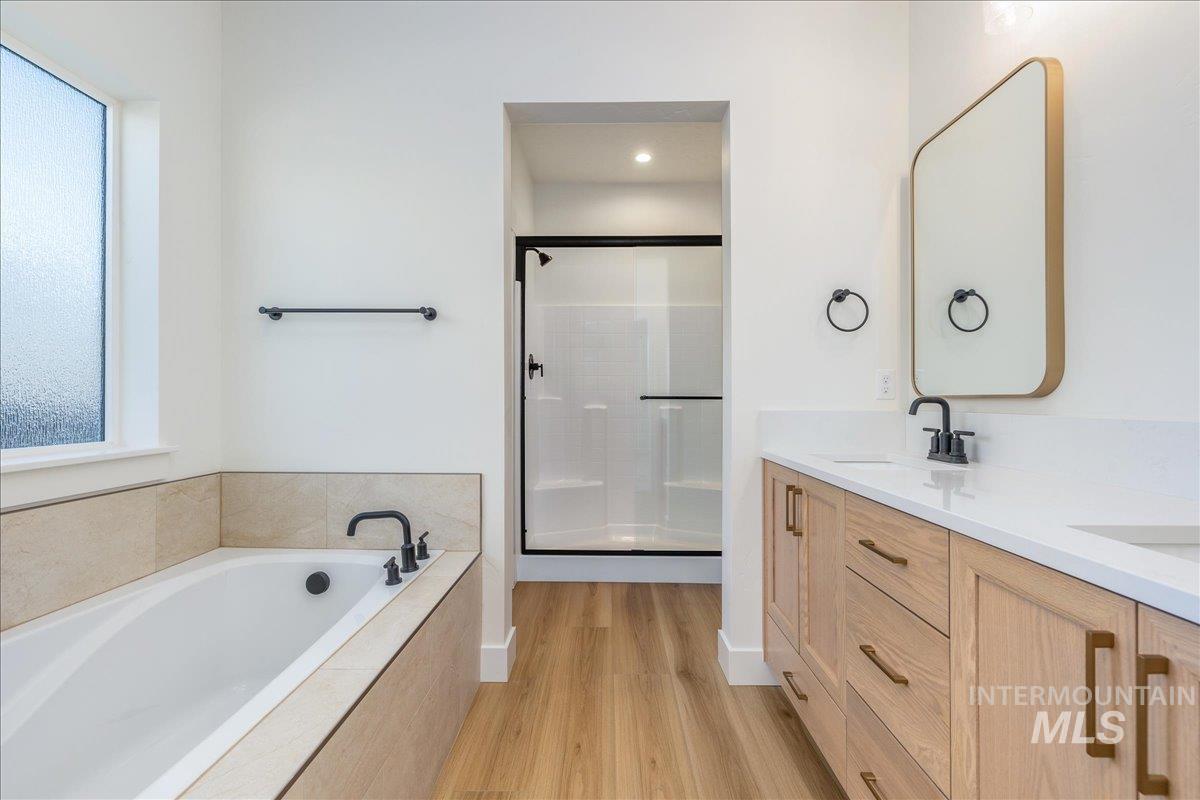 775 Pinehurst Street Payette, ID 83661 - Photo 20 of 36 Bathroom with double vanity, light wood-style floors, a shower stall, a bath, and plenty of natural light