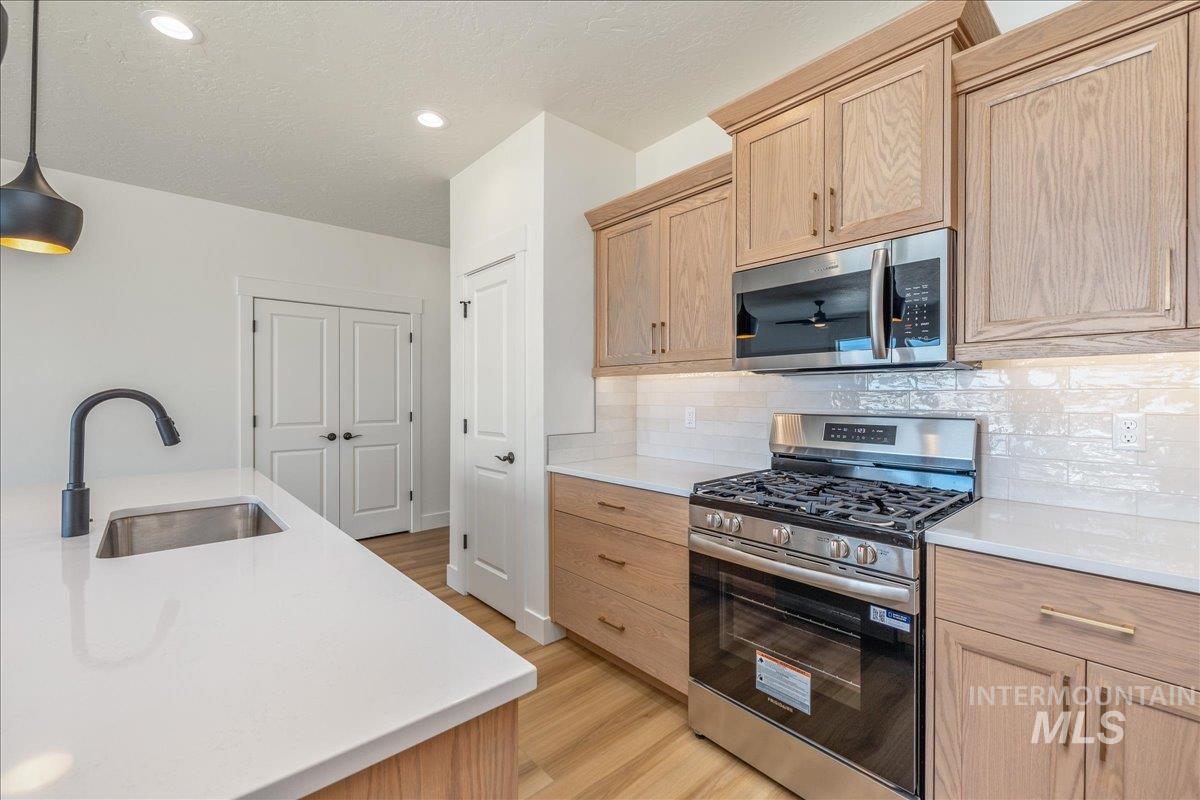 775 Pinehurst Street Payette, ID 83661 - Photo 7 of 36 Kitchen with appliances with stainless steel finishes, light brown cabinets, light wood finished floors, recessed lighting, and a textured ceiling