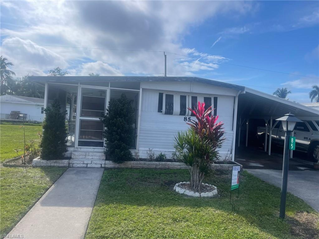 a view of a house with potted plants and a yard