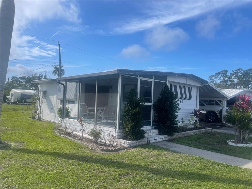 85 Enchanting Boulevard, Unit E85 Naples, FL 34112 - Photo 14 of 15 a front view of house with a garden and patio