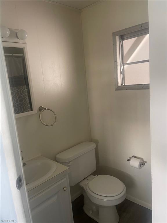 85 Enchanting Boulevard, Unit E85 Naples, FL 34112 - Photo 3 of 15 a white toilet sitting next to a bathroom sink and vanity