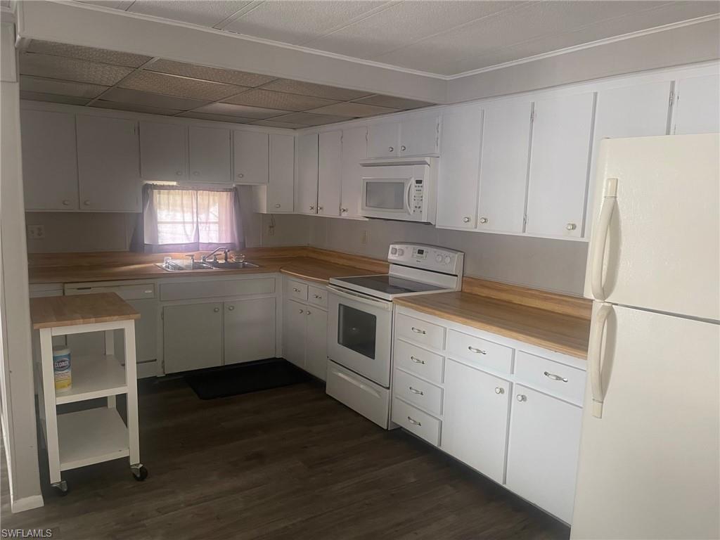 85 Enchanting Boulevard, Unit E85 Naples, FL 34112 - Photo 9 of 15 a kitchen with granite countertop white cabinets and white appliances