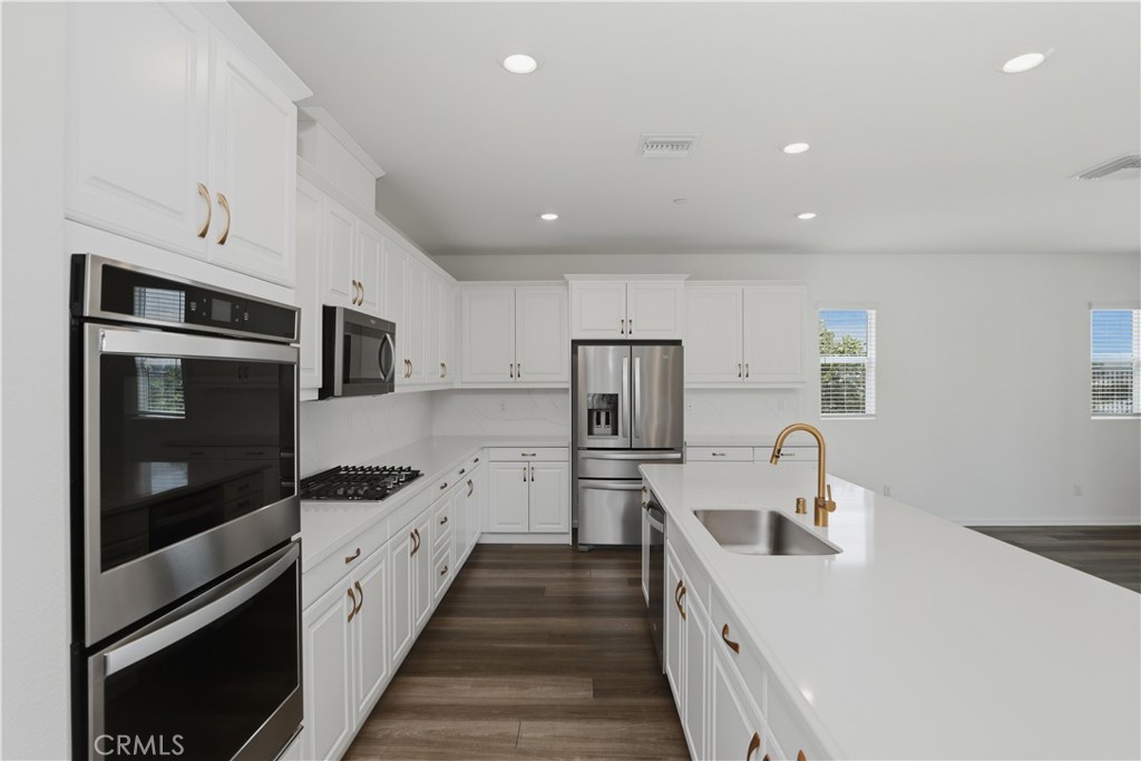21159 Blue Jeans Court Riverside, CA 92507 - Photo 24 of 63 a kitchen with white cabinets and stainless steel appliances