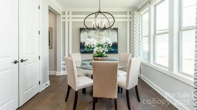 a dining room with furniture a chandelier and wooden floor