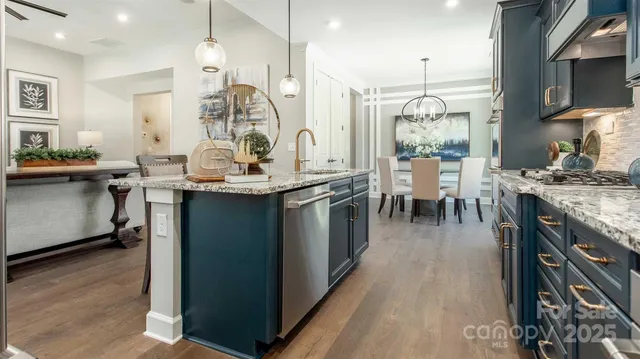 a kitchen with stainless steel appliances granite countertop a stove and cabinets