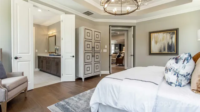 a spacious bedroom with a bed and dresser