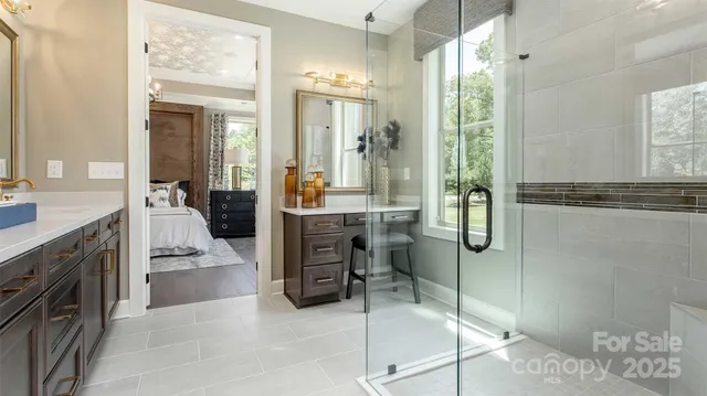 a en suite bathroom with a double vanity sink a large mirror and a shower
