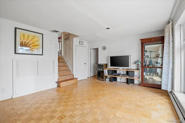 a view of a livingroom with wooden floor and a flat screen tv