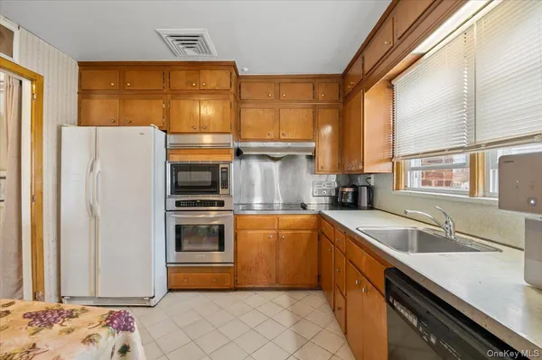 a kitchen with a refrigerator sink and cabinets