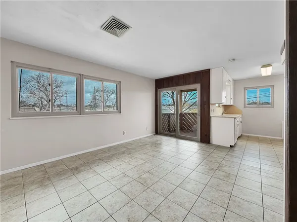a view of an empty room with window and cabinet