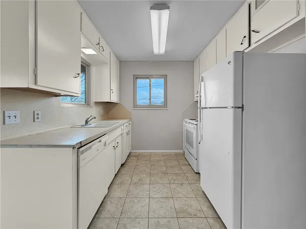 a kitchen with granite countertop a sink stove and refrigerator