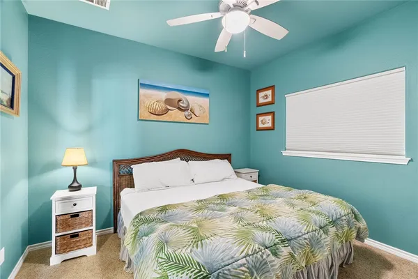 a bedroom with a bed and a lamp on dresser