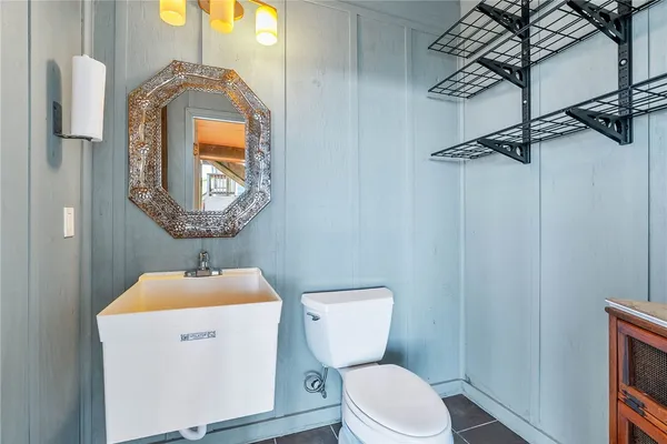a bathroom with a toilet sink vanity and mirror