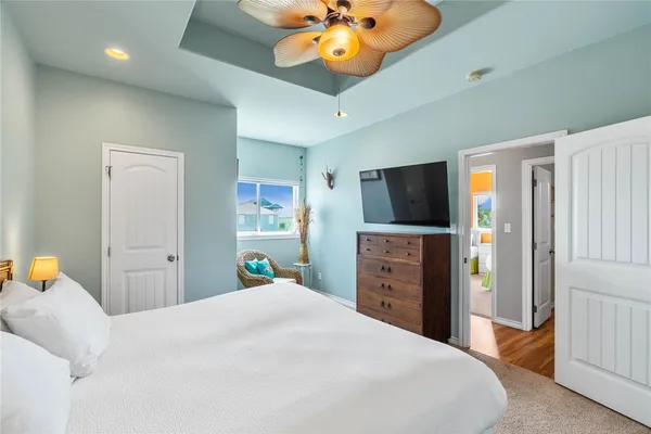 a bedroom with a bed and a flat tv screen on dresser