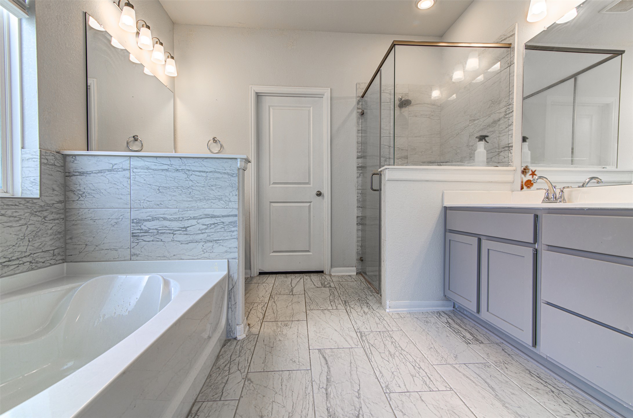 774 Cherrystone Loop Buda, TX 78610 - Photo 18 of 38 Indulge in a primary bathroom featuring a spacious soaking tub and a sleek glass-enclosed shower.