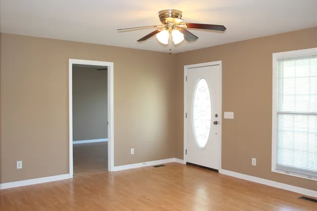 an empty room with closet and a chandelier fan