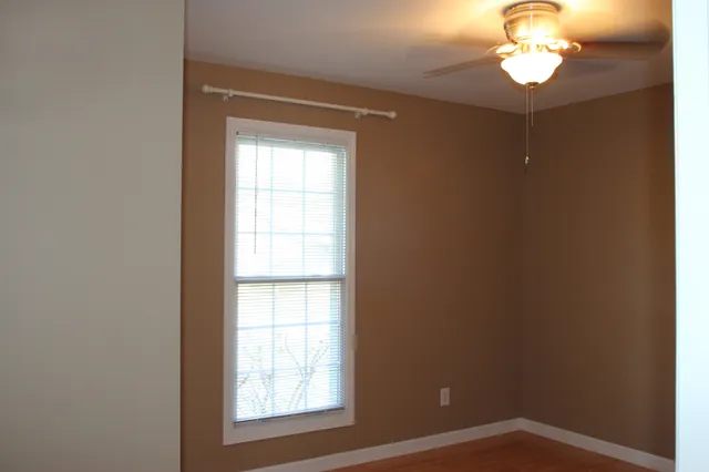 a view of an empty room with closet and a window