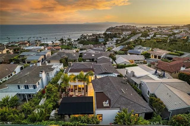 an aerial view of a city with lots of residential buildings and ocean view in back