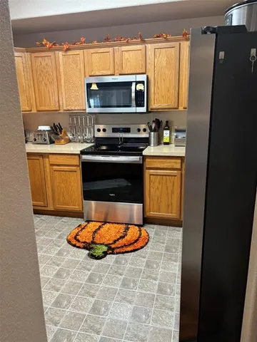 a kitchen with stainless steel appliances a stove a microwave and a sink