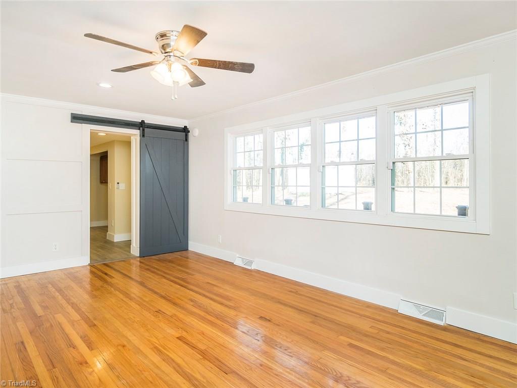 209 Edgeview Road High Point, NC 27260 - Photo 5 of 20 Spacious living room with beautiful hard wood flooring throughout. Barn door leading to Master bedroom, laundry room and garage. Large windows for added natural lighting, ceiling fans, and easy access to kitchen.