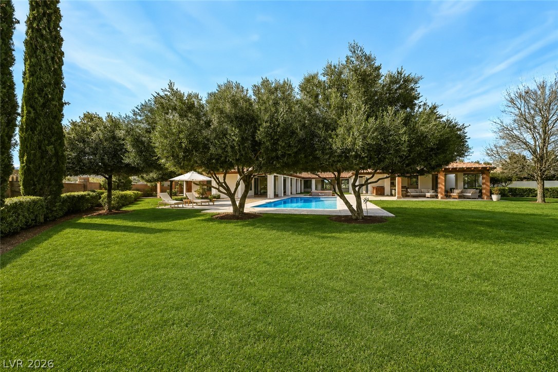 1140 Julie Road Henderson, NV 89002 - Photo 5 of 38 A spacious, verdant lawn with mature trees leads to a tranquil pool & spa.