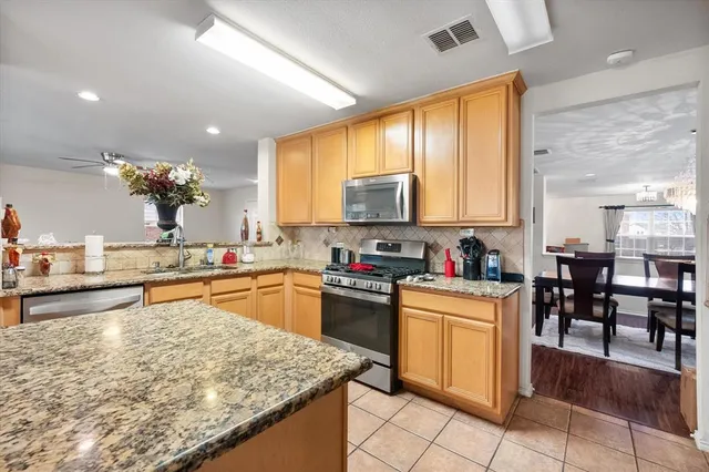 a kitchen with stainless steel appliances granite countertop sink stove top oven and cabinets