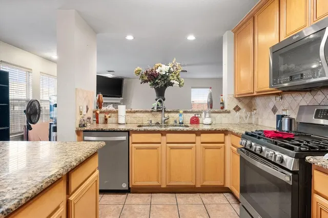 a kitchen with stainless steel appliances granite countertop a sink stove and cabinets