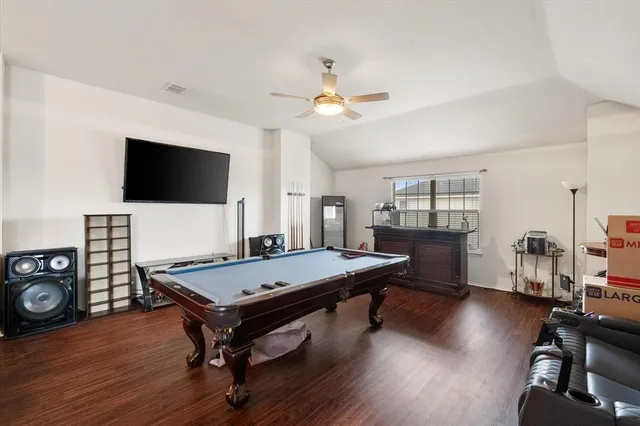 a room with wooden floor and pool table