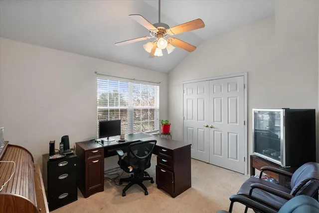 a view of a workspace with furniture and a window