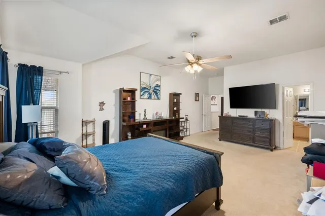 a spacious bedroom with a bed and a flat screen tv