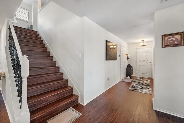 a view of a livingroom with wooden floor and stairs