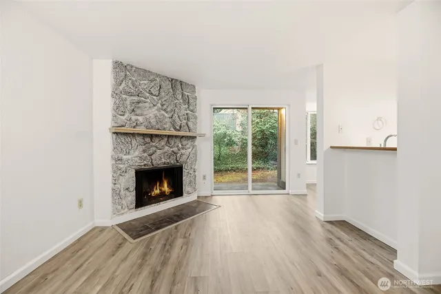 a view of empty room with wooden floor and fireplace
