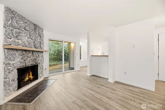 a view of empty room with wooden floor and fireplace