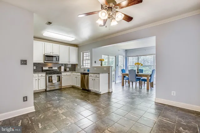 a kitchen with cabinets and chairs