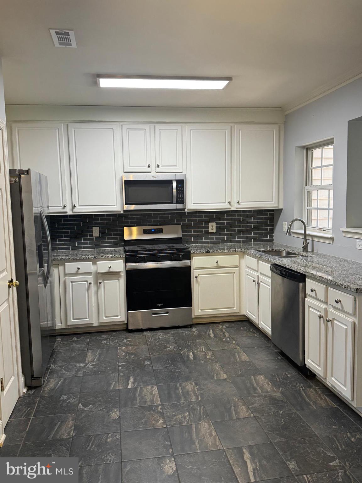 3850 Koval Lane Woodbridge, VA 22192 - Photo 9 of 61 a white kitchen with granite countertop a stove top oven sink and cabinets