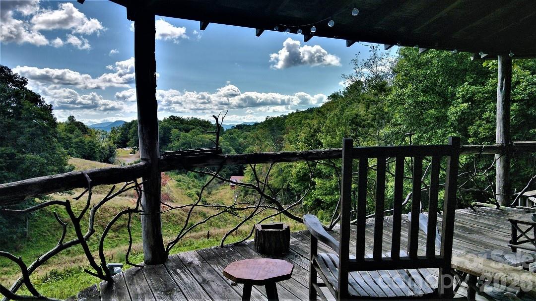 745 Broom Road Tuckasegee, NC 28783 - Photo 2 of 42 a view of a balcony with chair and wooden floor