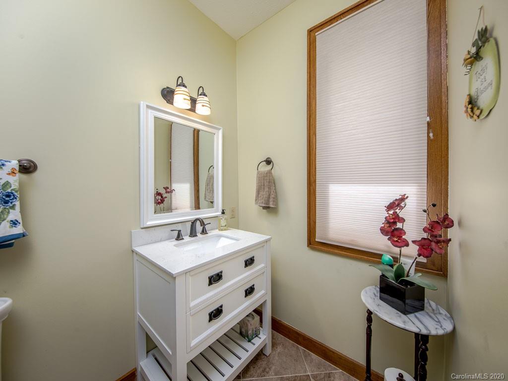 270 Country Ridge Road Laurel Park, NC 28739 - Photo 14 of 39 a bathroom with a sink mirror and vanity