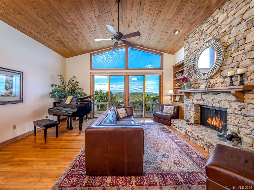 270 Country Ridge Road Laurel Park, NC 28739 - Photo 7 of 39 a living room with furniture a fireplace a rug and a floor to ceiling window