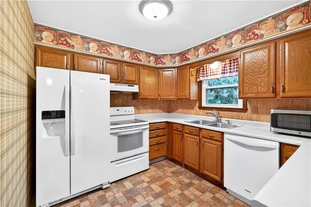 a kitchen with stainless steel appliances granite countertop a stove a sink and a refrigerator