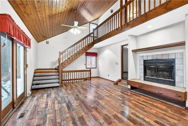 an empty room with windows and fireplace