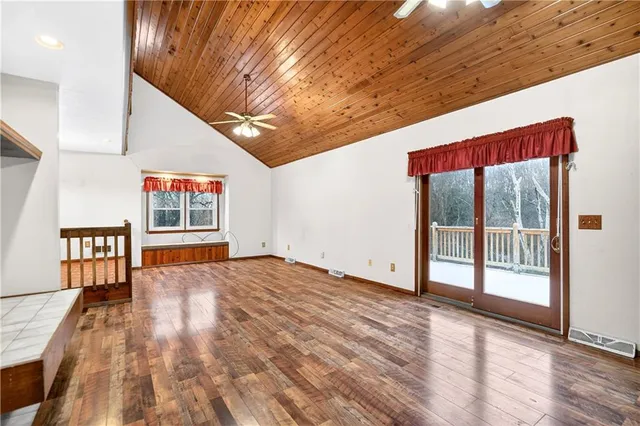 a view of a roof deck with wooden fence and trees