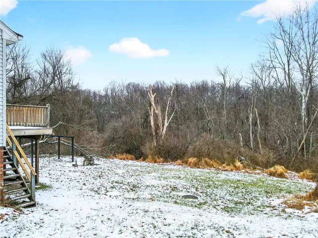 a view of wooden house and snow on the road