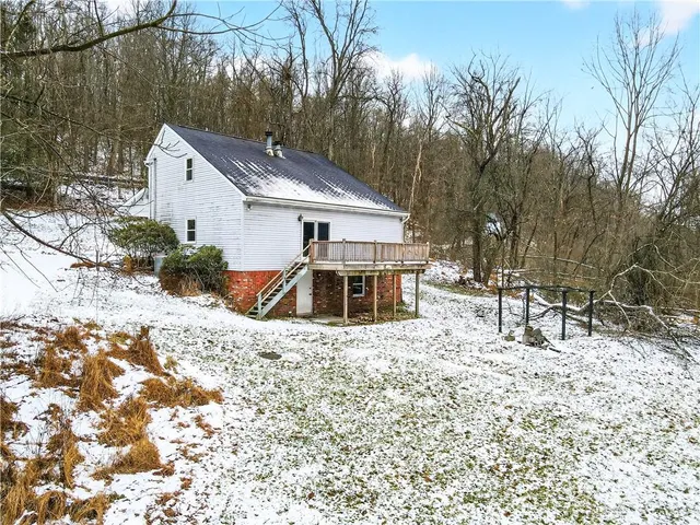 a front view of a house with a yard covered with snow