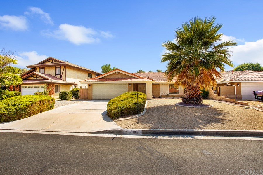 12905 Rain Shadow Road Victorville, CA 92395 - Photo 1 of 1 a front view of a house with a yard and garage