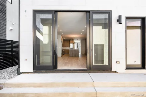 a view of a hallway with wooden floor and a glass door