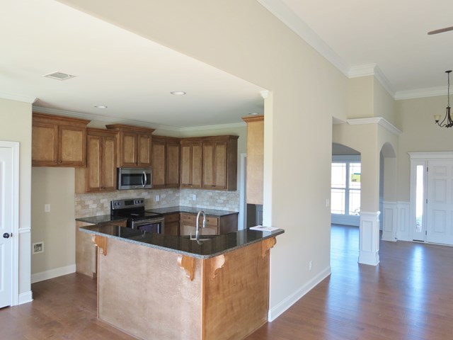 904 Rainbow Springs Road Macon, GA 31216 - Photo 10 of 16 a kitchen with stainless steel appliances granite countertop a stove a sink a refrigerator white cabinets and wooden floor