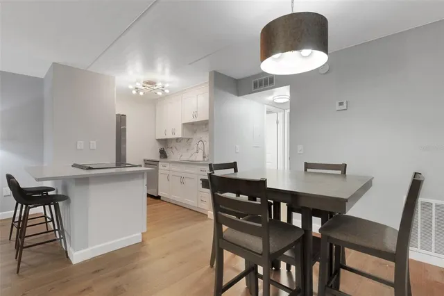 a kitchen with a dining table chairs and white cabinets